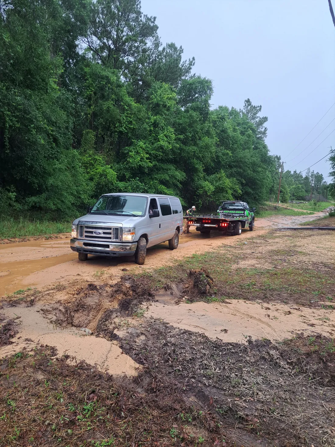Gibby's Towing flatbed tow truck recovering a stranded van on a washed-out road in Mobile, AL, serving Saraland, Theodore, Prichard, Semmes and Tillman's Corner